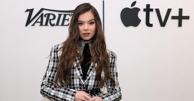 Hailee Steinfeld in a black top, and black and white check jacket.