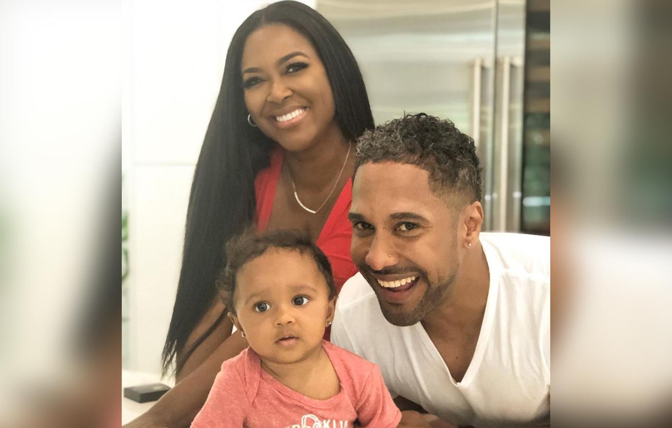 Kenya Moore, Marc Daly take a photo with their baby.