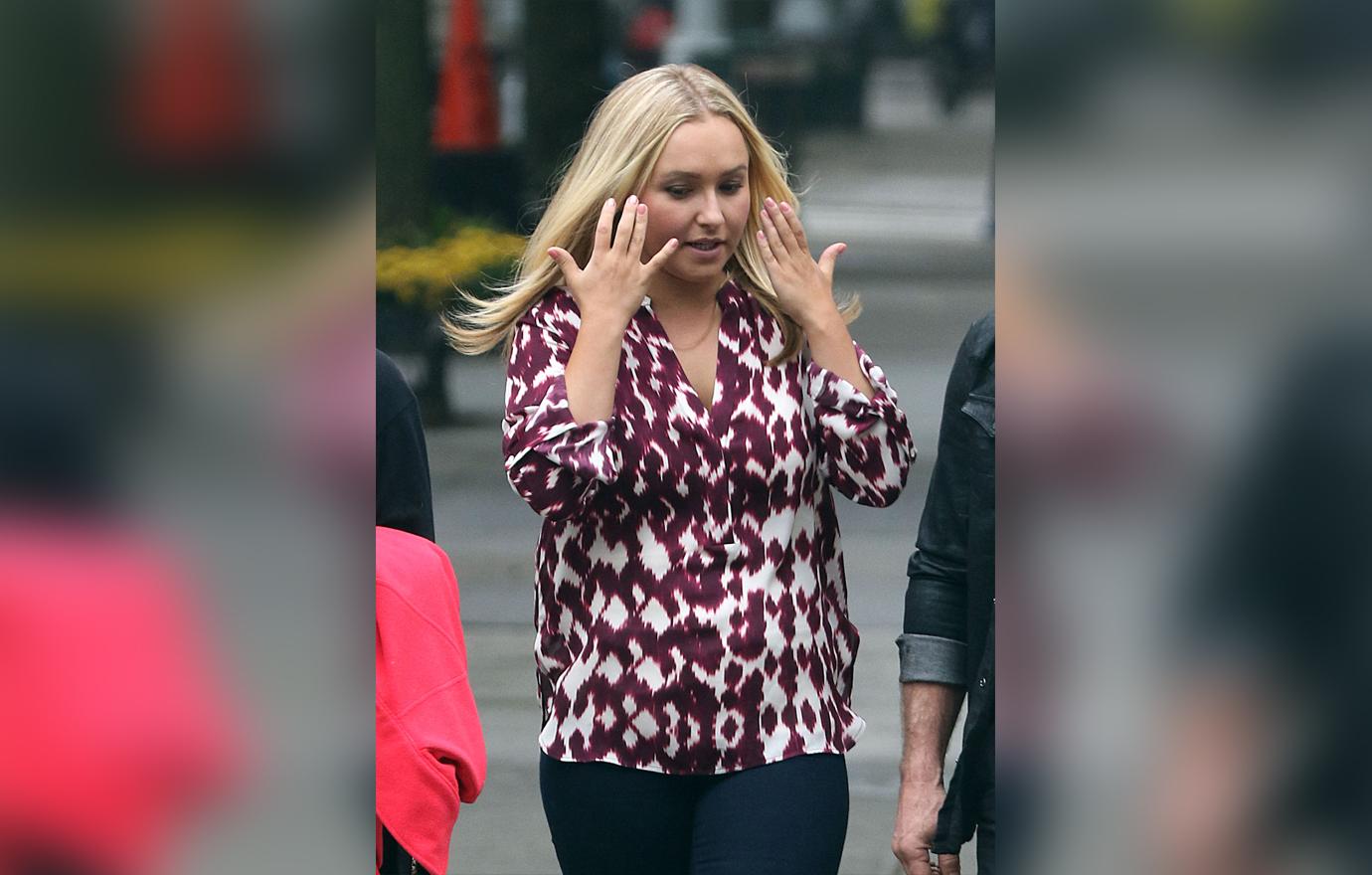 Hayden Panettiere Wears Printed Purple Shirt With Hands Raised Towards Her Face with Exasperated Expression