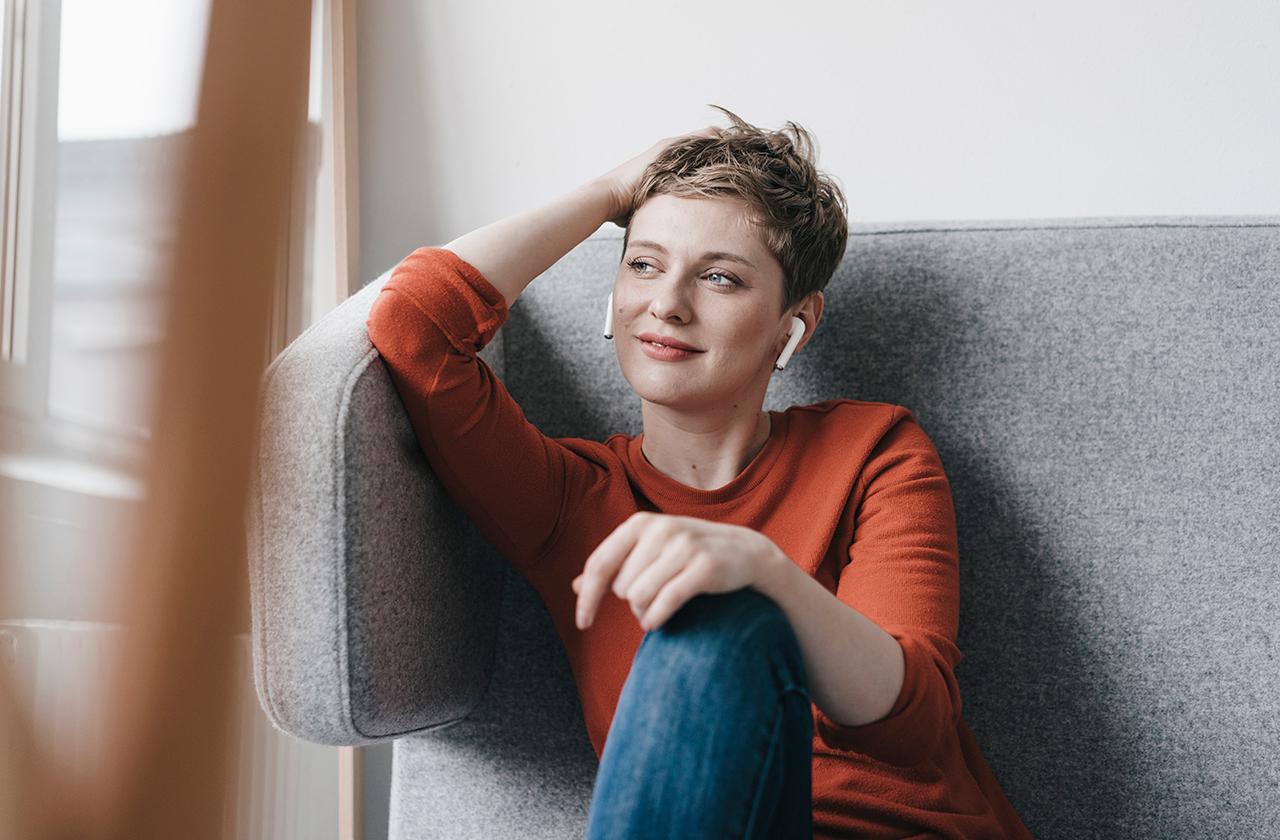 Smiling woman with wireless earphones