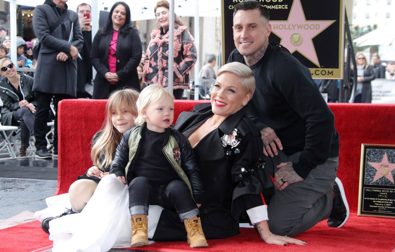 Pink , Carey Hart, and their kids post on the walk of fame.