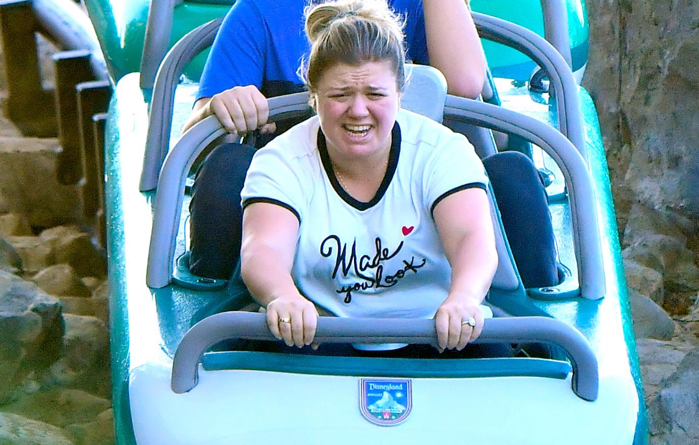 Kelly Clarkson in the front row of a ride at Disneyland, squinting as the cart plunges down a hill