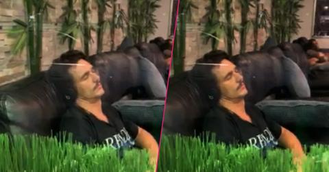 James Franco wears a black shirt while sleeping on the massage chair listening to music.