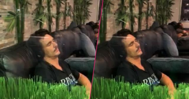 James Franco wears a black shirt while sleeping on the massage chair listening to music.
