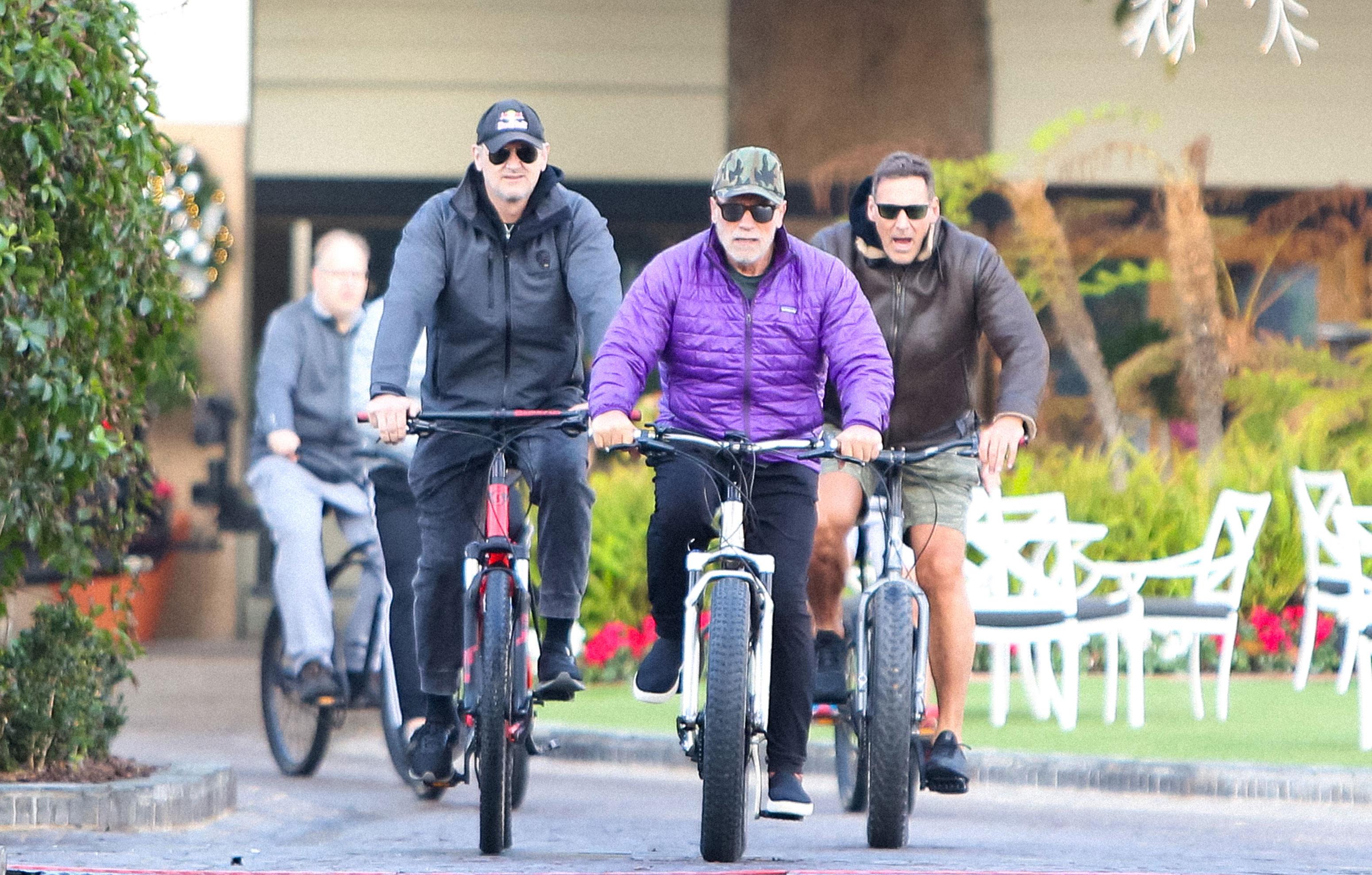 arnold schwarzenegger looks glum photos riding bike male friend maria shriver divorce settlement millions