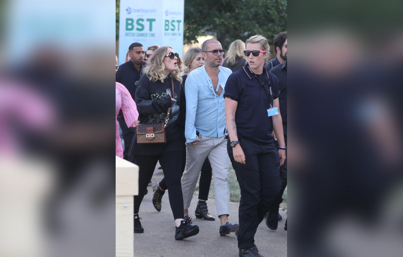 Adele is seen surrounded by bodyguards while holding hands with a male friend in Hyde Park, London, where Celine Dion was headlining.