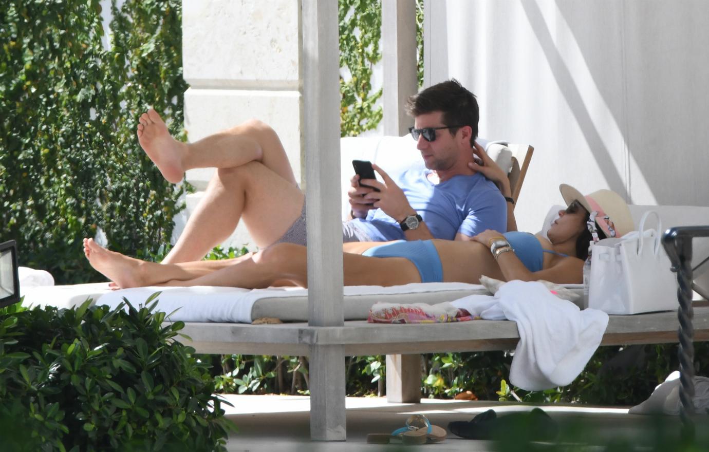 Paul Bernon, in shorts, lays next to Bethenny Frankel who wears a bikini.