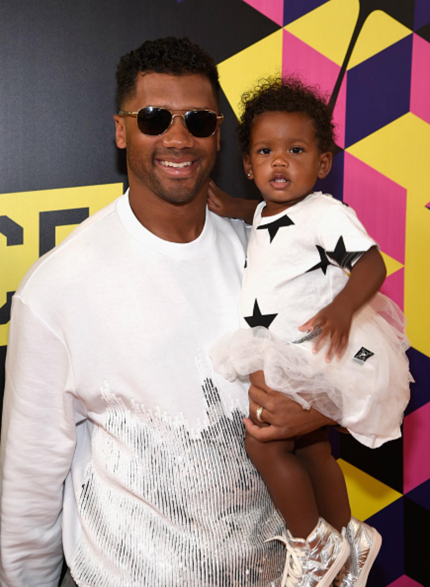 Russel Wilson holds his baby daughter, Sienna Princess Wilson.