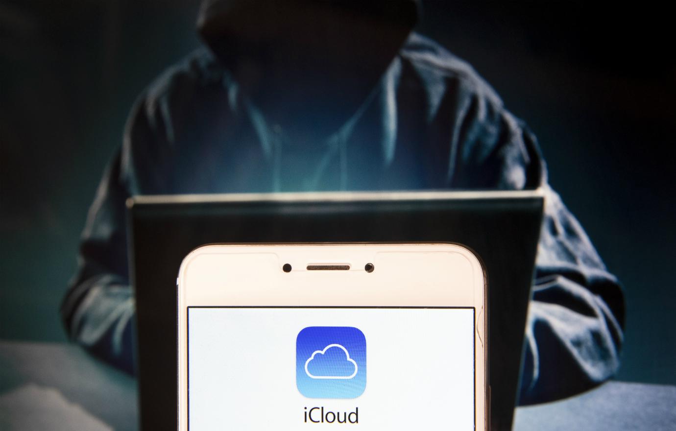 In this photo illustration, the American file hosting service company owned by Apple, Icloud, logo is seen displayed on an Android mobile device with a figure of hacker in the background.