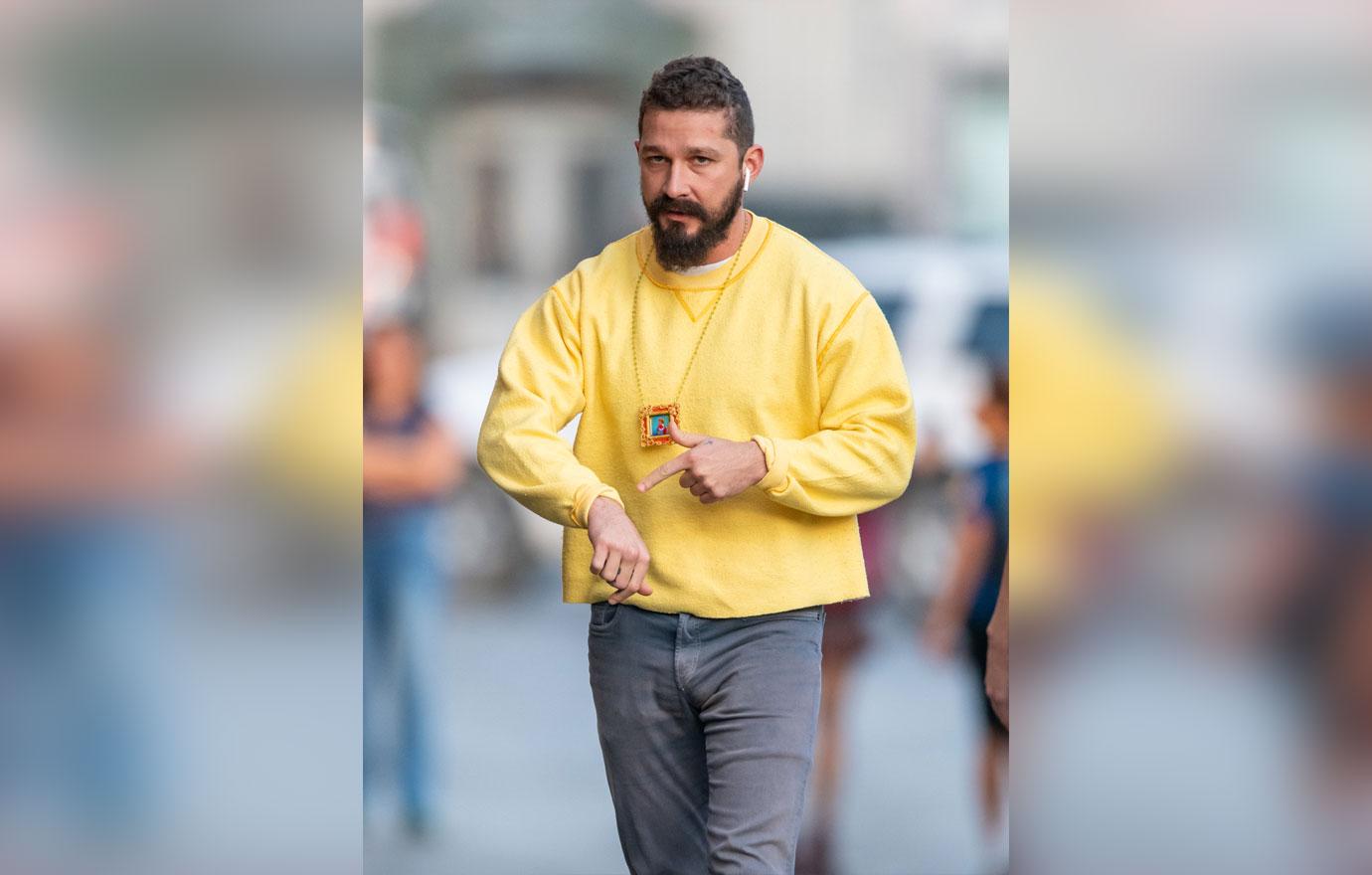 Shia LaBeouf With Full BeardWalking Down the Street Wearng AirBuds and Yellow Sweatshirt, I