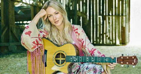 Jewel Sitting with a Guitar on a Chair in a Barn