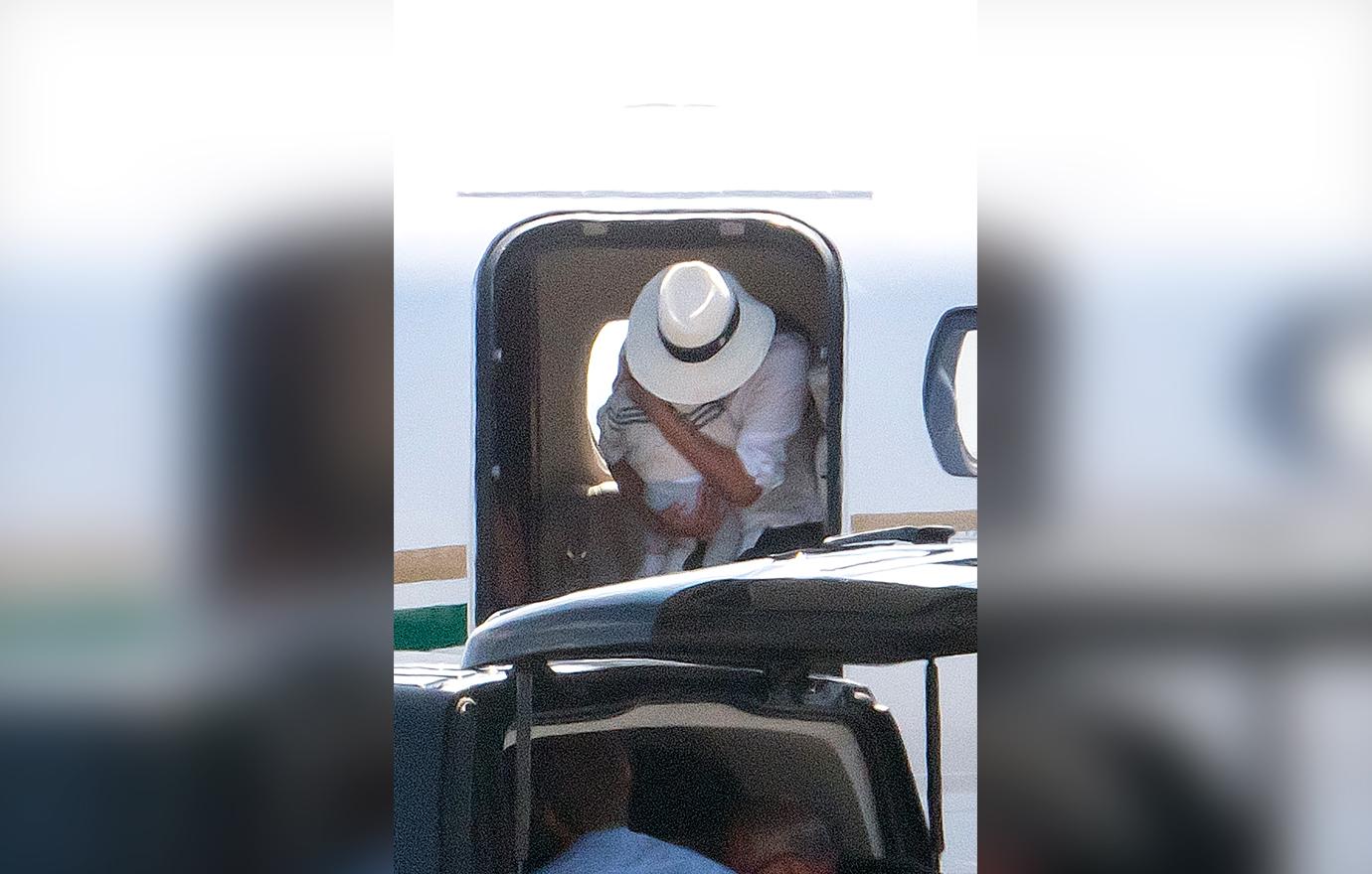 Meghan Markle cradles baby son Archie in both arms as she leaves the luxury private jet