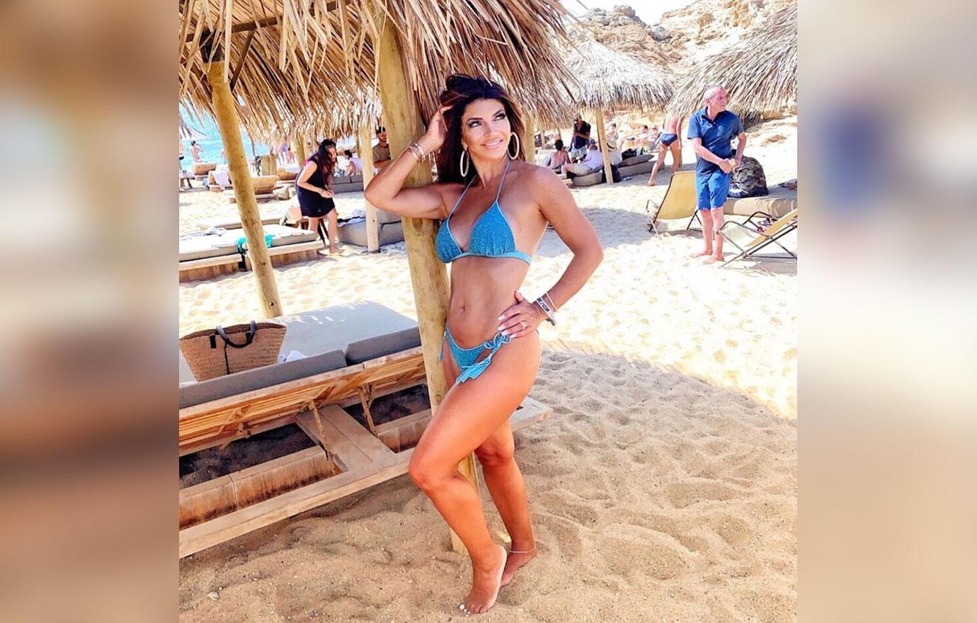 Teresa Giudice Standing In The Sand Wearing A Blue Bikini