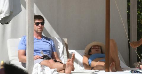 Paul Bernon, in a blue t-shirt, lays on a lounger next to Bethenny Frankel who wears a matching blue swimsuit.