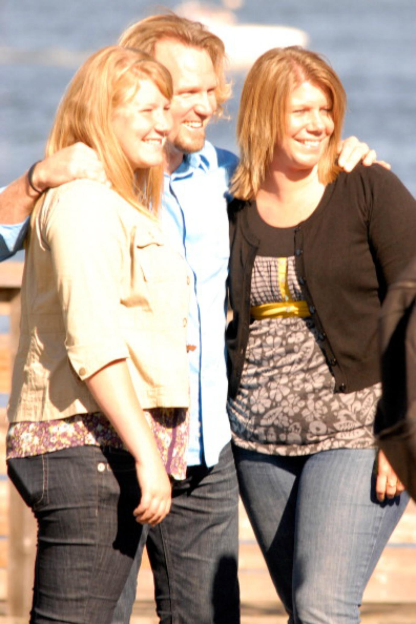 Kody Brown poses for a photo outside with two members of his family.