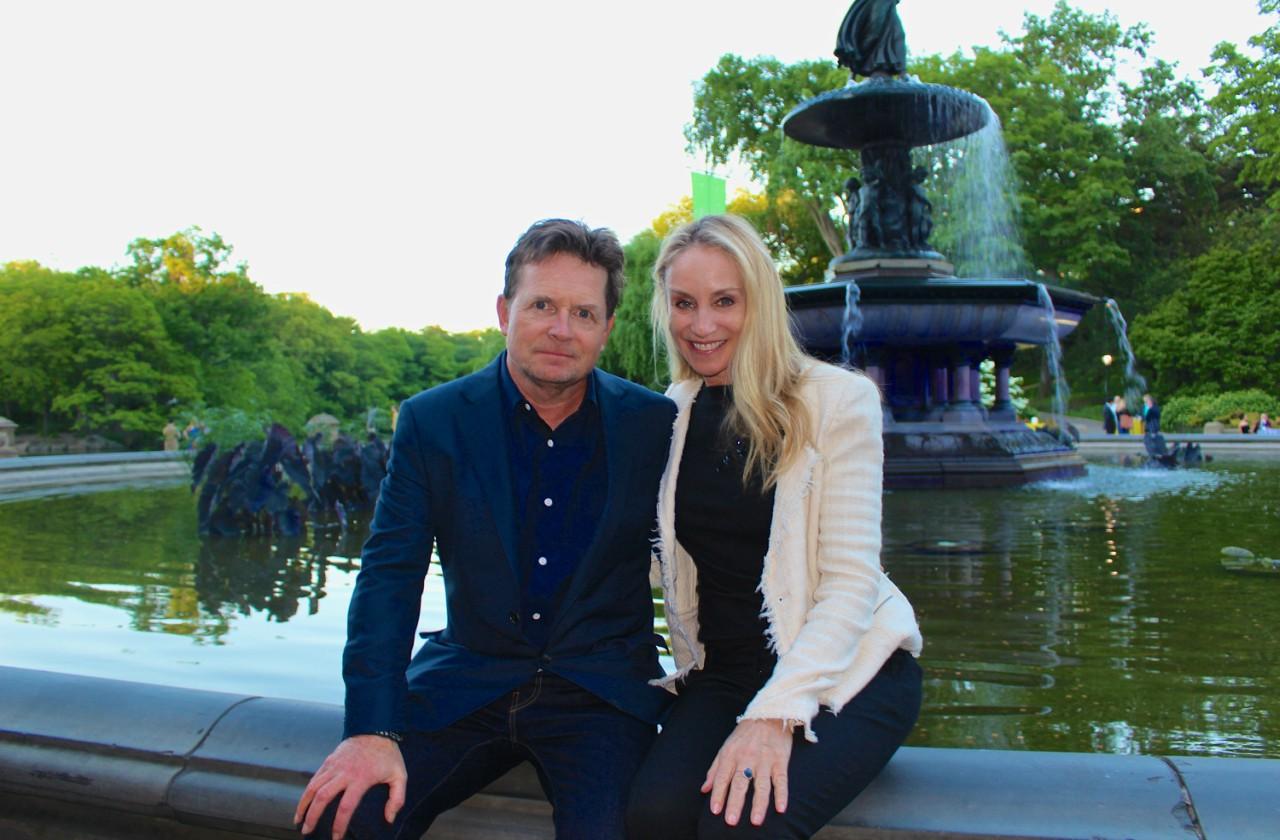 Michael J Fox and wife, Tracy, sit in front of fountain in Central Park