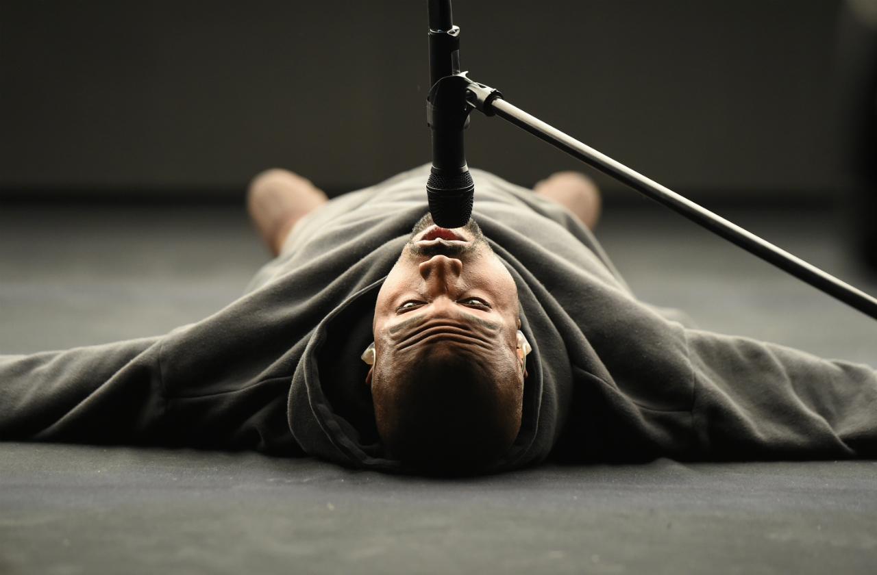 Kanye West on the floor with microphone while performing on February 15, 2015