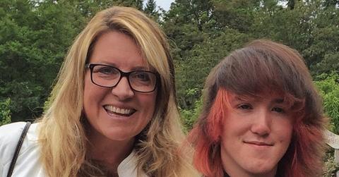 Delilah wears a white shirt and her son Zach is wearing a black shirt and has red dyed hair.