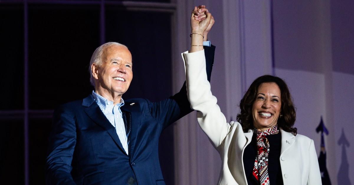 Joe Biden and Kamala Harris smiling and holding hands.