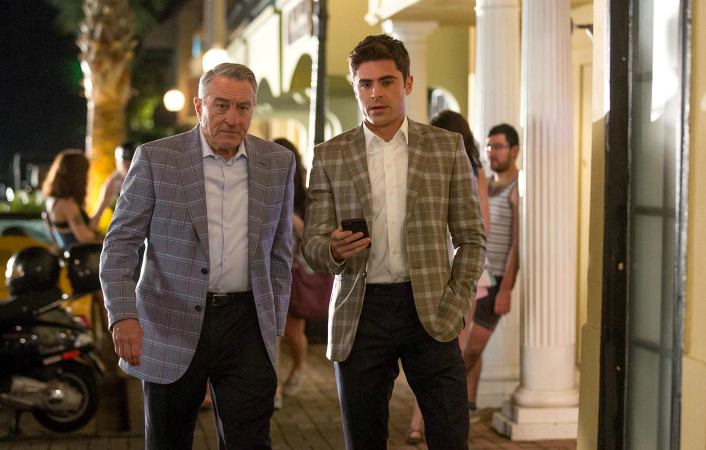 Zac Efron and Robert DeNiro walk together with matching plaid sports jackets.