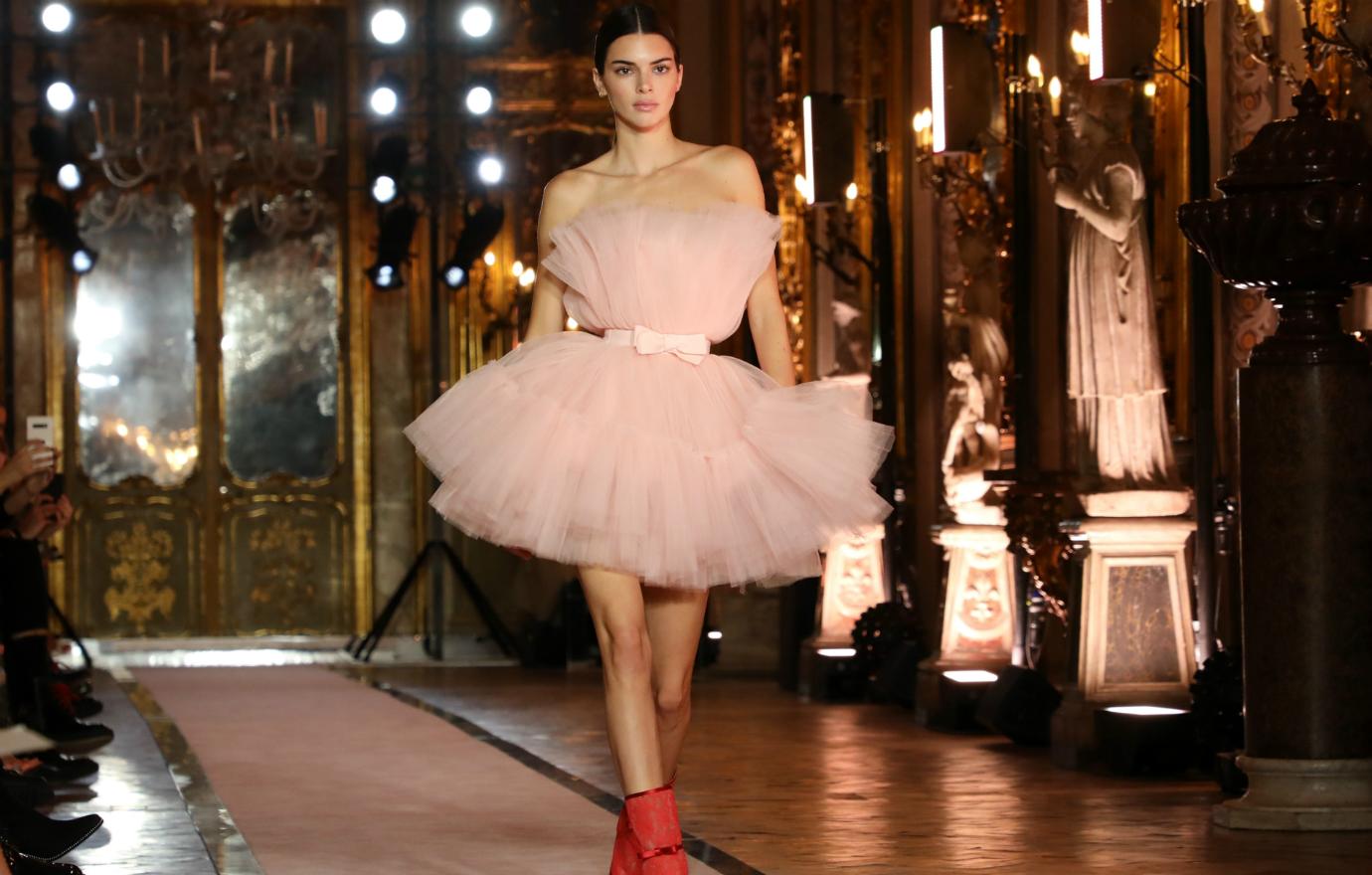 Kendall Jenner walked the catwalk in a pastel pink strapless dress that featured a bow waistband — paired with red boots.