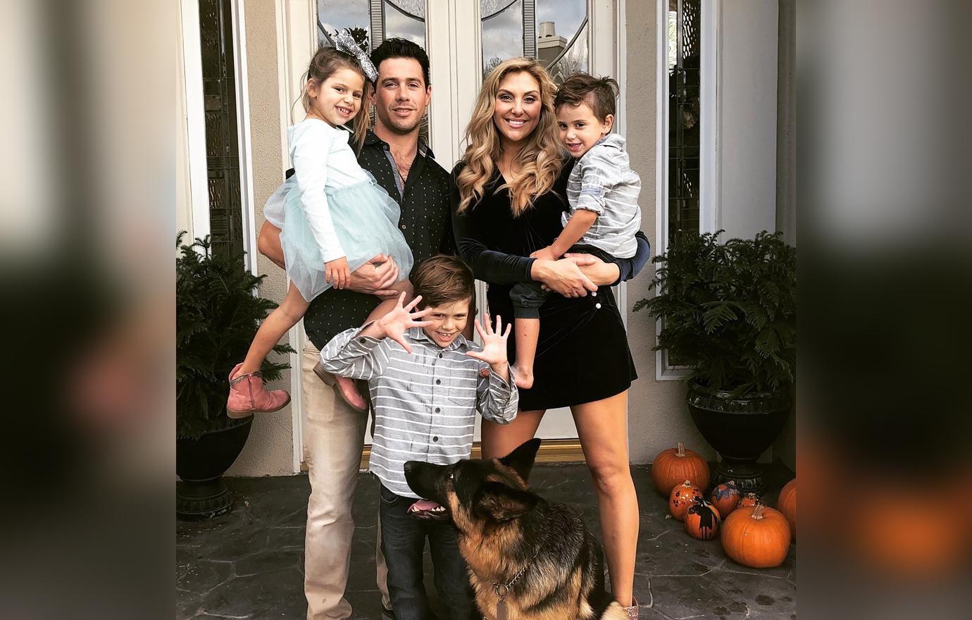 Gina Kirschenheiter and Matt Kirschenheiter Pose Outside Holding Children With Dog On Front Porch