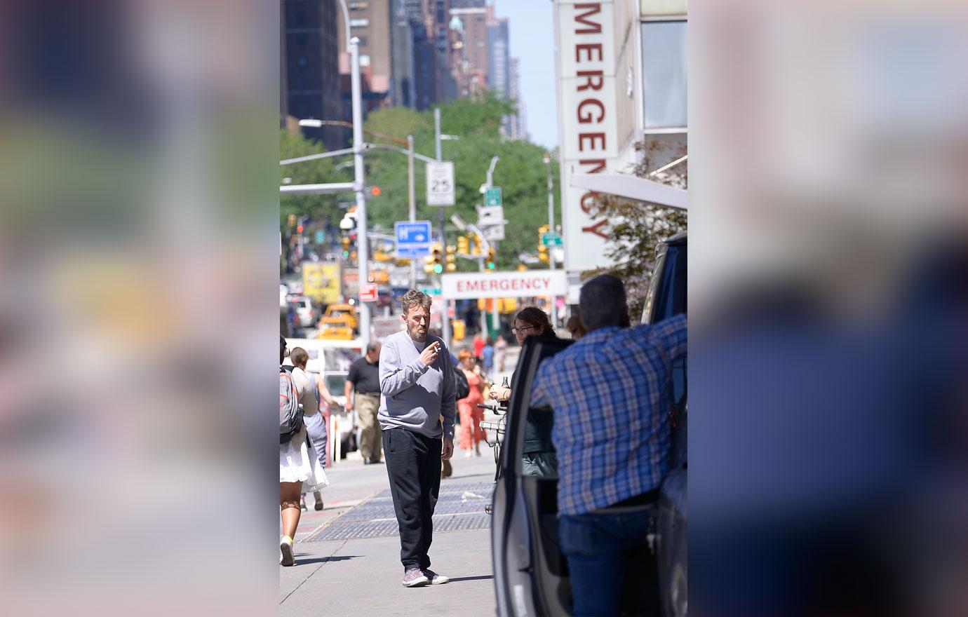 Matthew Perry Wearing Grey Top Smoking a Cigarette On A NYC Street In Font Of Hospital