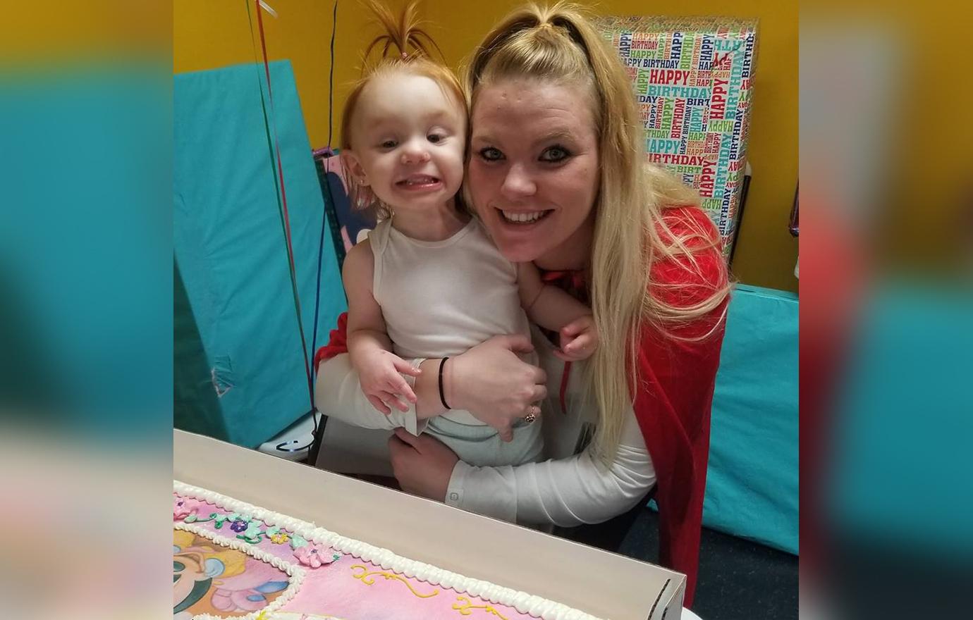 Victoria Messer Sitting Holding Toddler Daughter Wearing A Red Cape