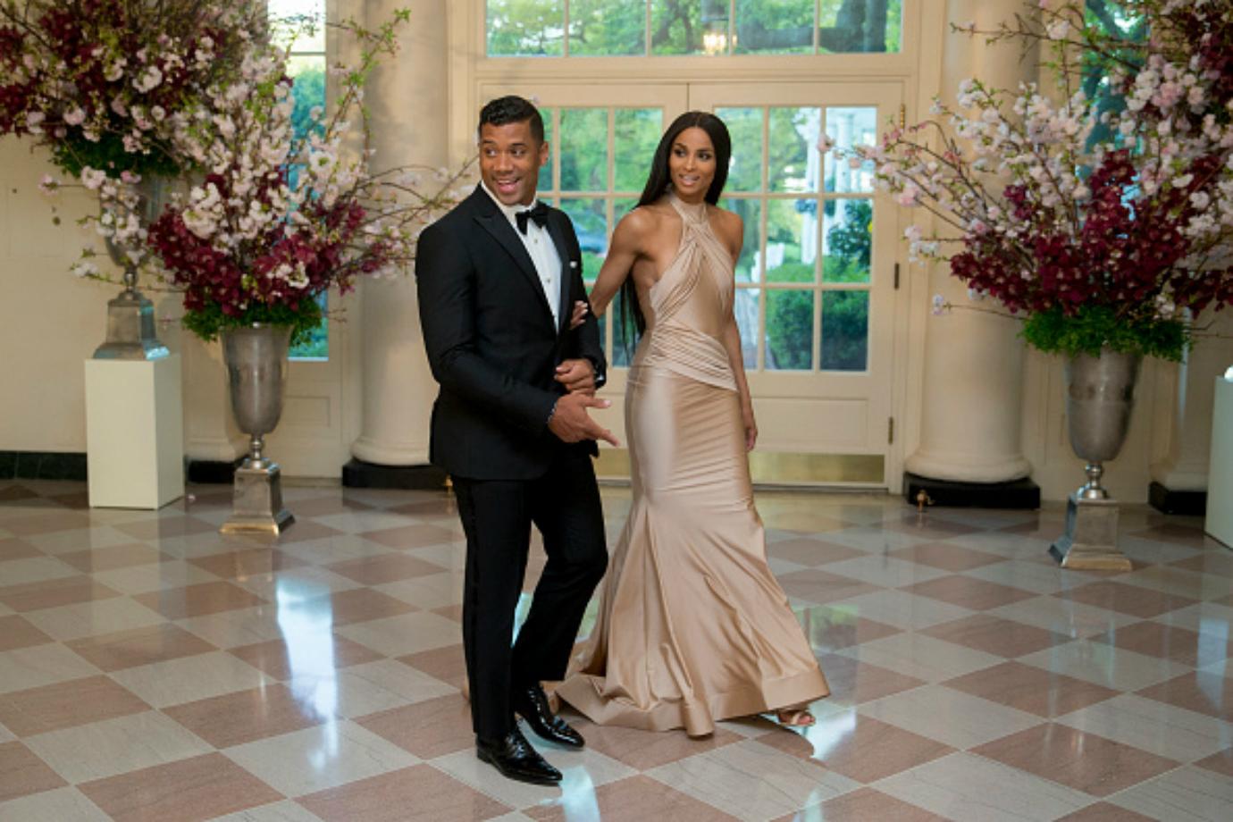 Russel Wilson and Ciara walk hand in hand into the White House.