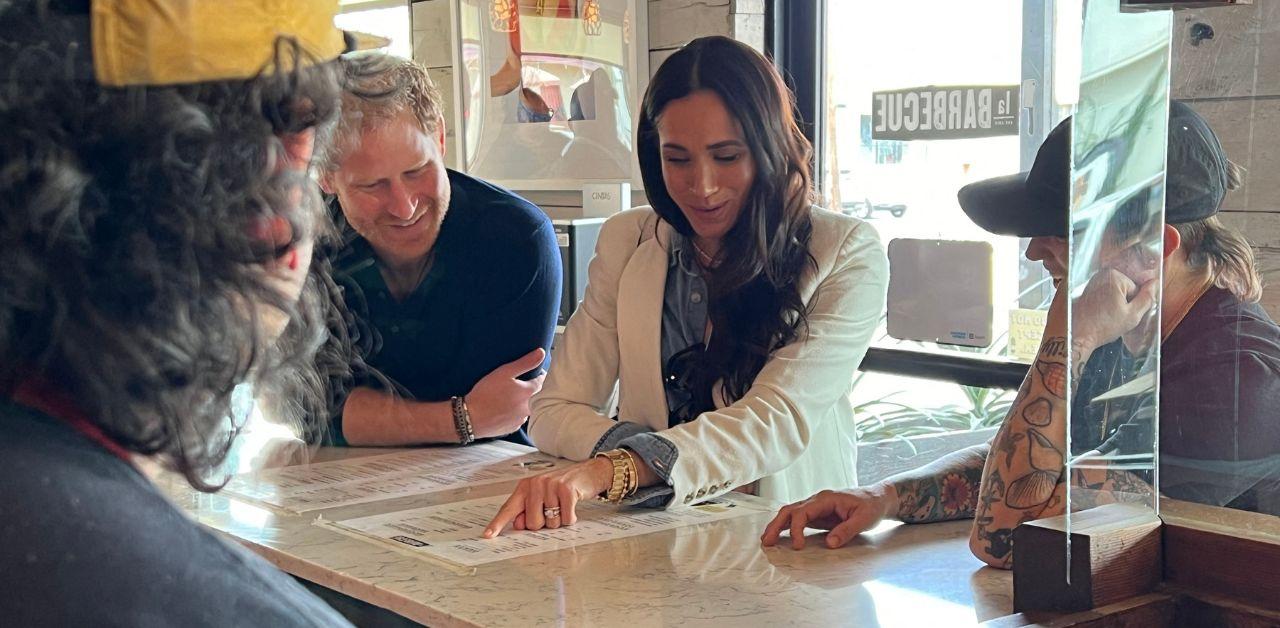 A photo of Meghan Markle and Prince Harry looking at a menu.