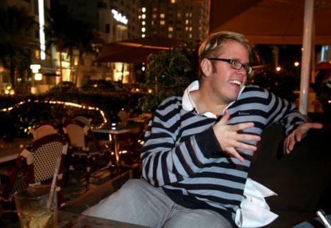 Perez Hilton talks in a chair.