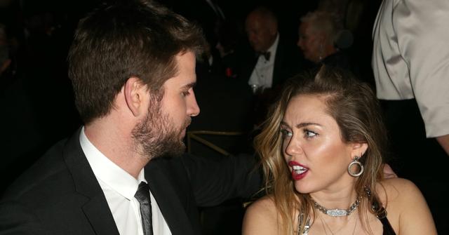 Liam Hemsworth, in a black suit, and Miley Cyrus, in a plunging black dress, during happier days before their divorce.