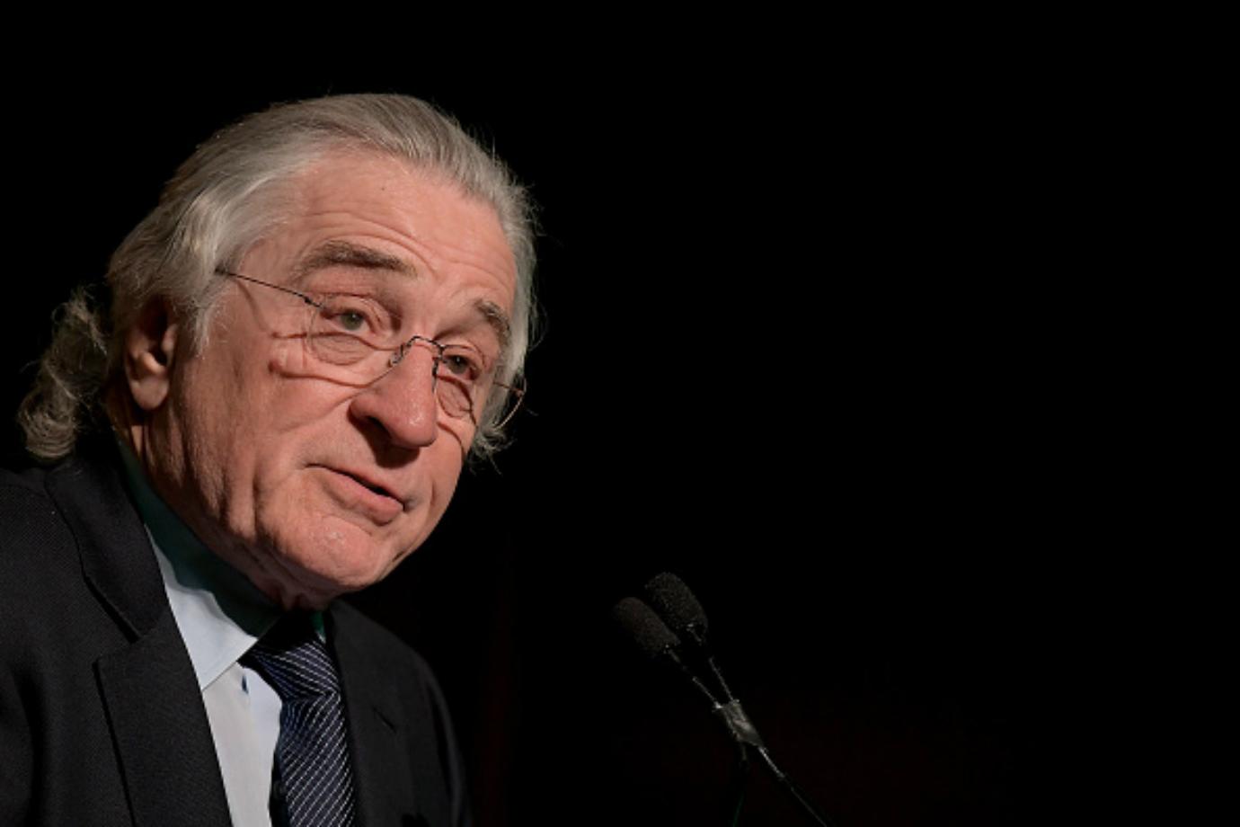 Robert De Niro speaks at a podium.