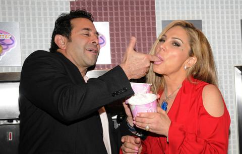 Paul Nassif, in black, feeds Adrienne Maloof, in red, some ice cream by hand.