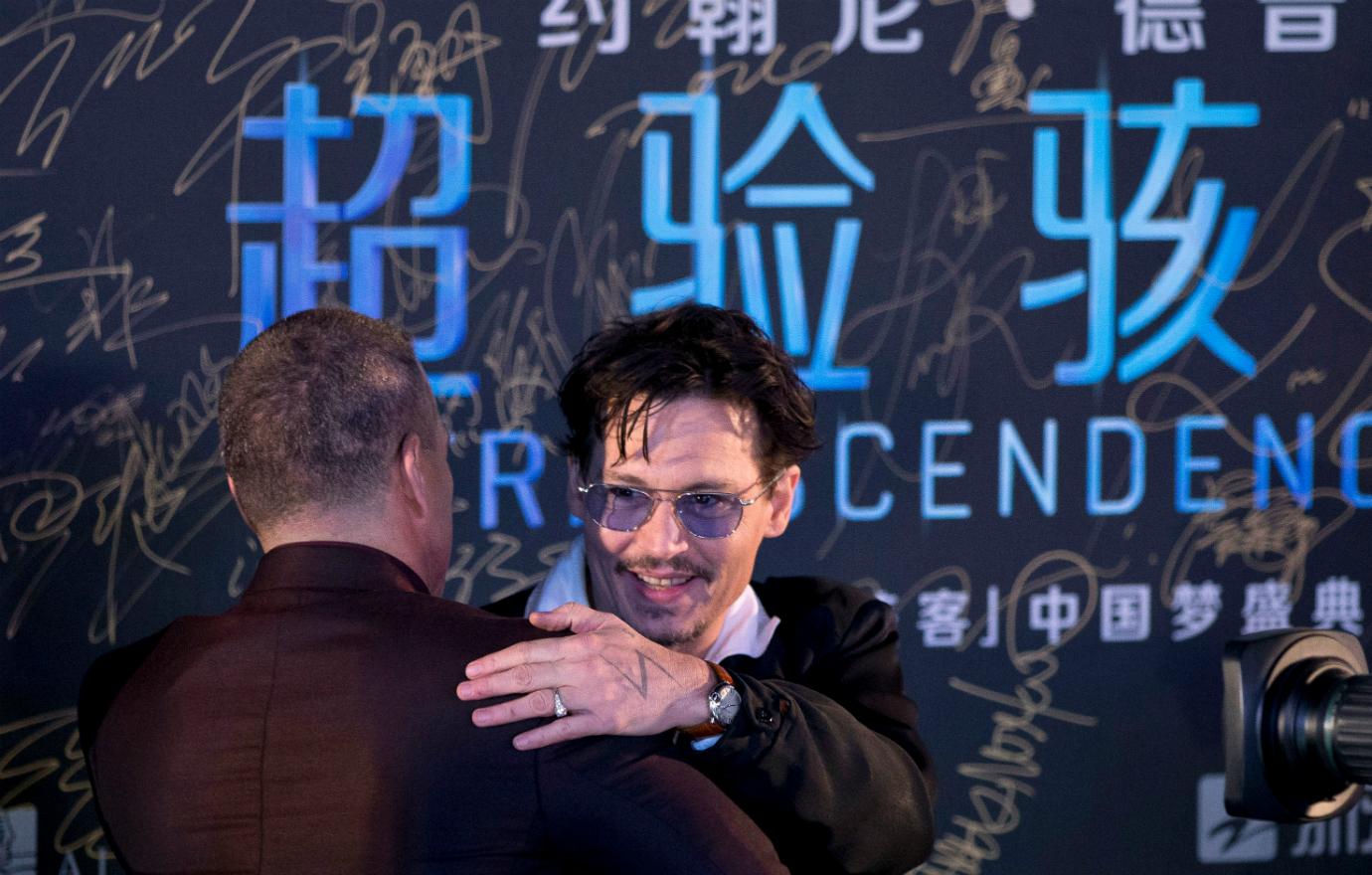 Johnny Depp hugged a friend on the black carpet for his film while showing off his diamond engagement ring on his ring finger.