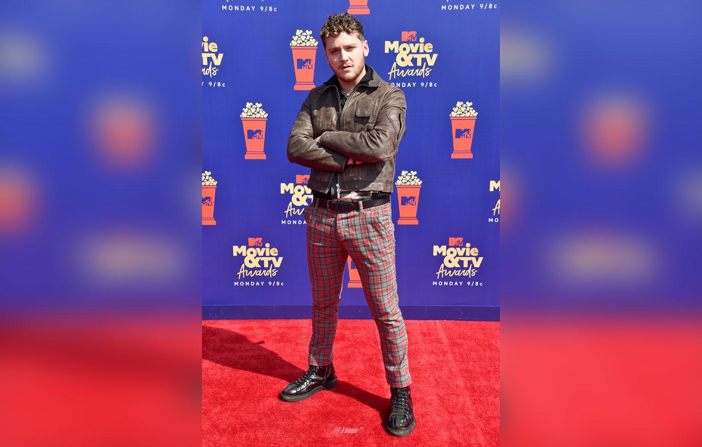 Bazzi wears a brown jacket and flannel pants.