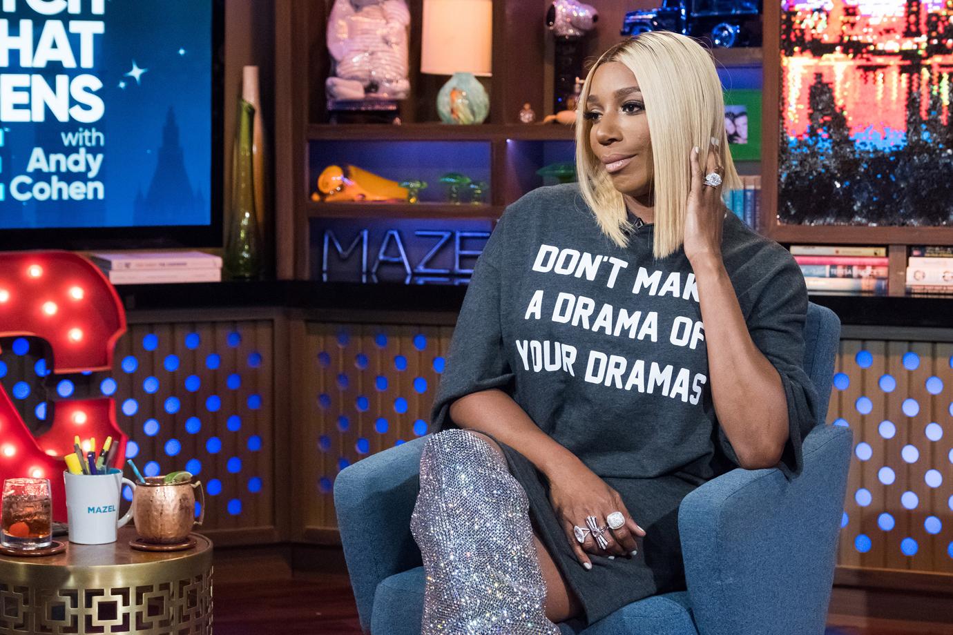 NeNe Leakes With Short Blonde Hair With Sparkly Knee High Boots and Over-sized Tee Looking Unimpressed on Set of WWHL With Andy Cohen