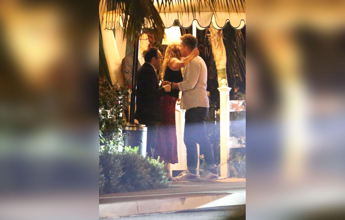 Jennifer Aniston kisses a male friend goodbye after having dinner in Los Angeles. The 50 year old actress is wearing a red skirt with a black top. She dined at the restaurant with a few friends including a mystery man who she gave a hug and a kiss to on the cheek before departing.