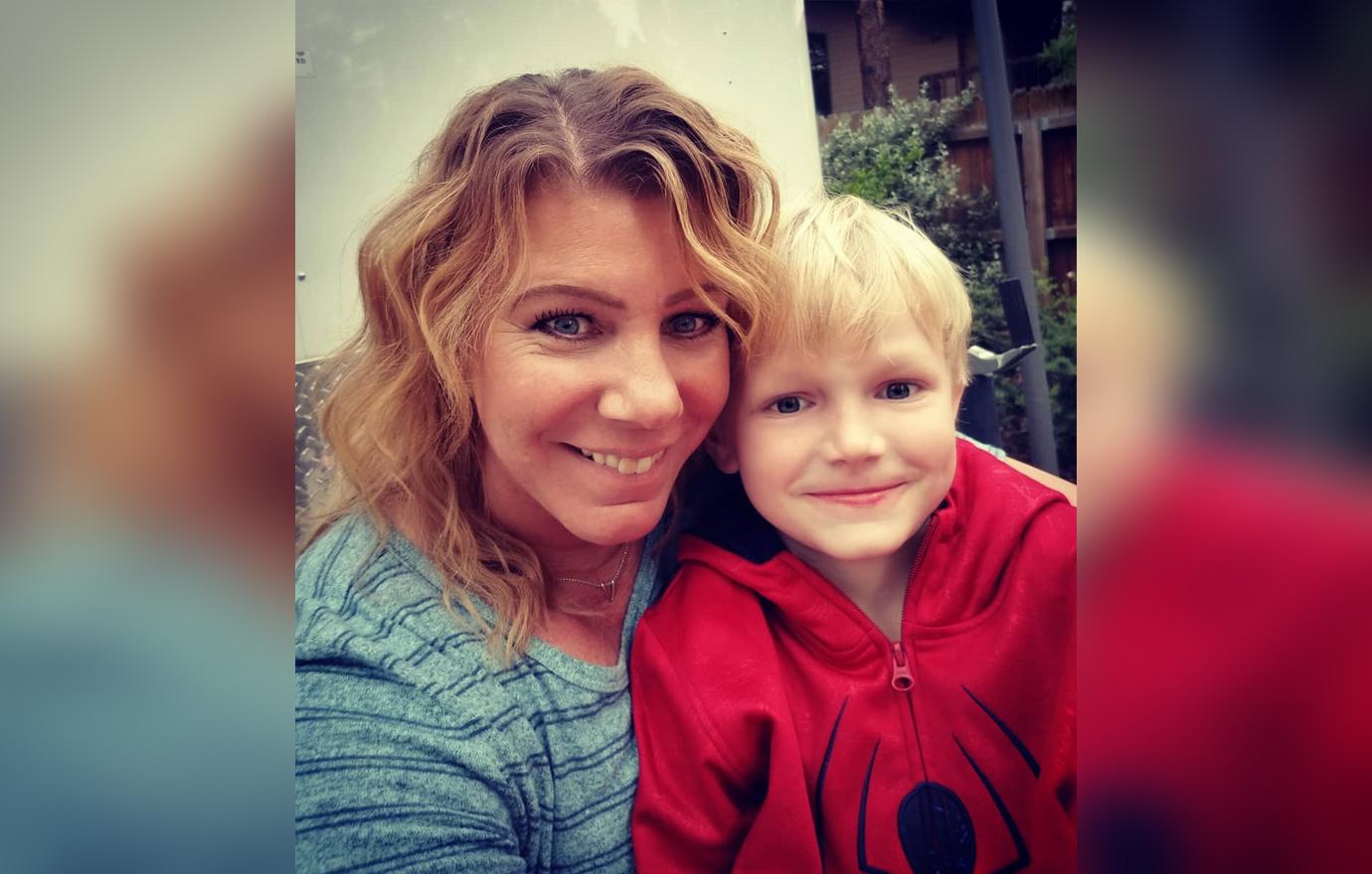 Meri Brown takes a selfie whilst wearing a blue shirt with stripes with her son who is wearing a spiderman hoodie.