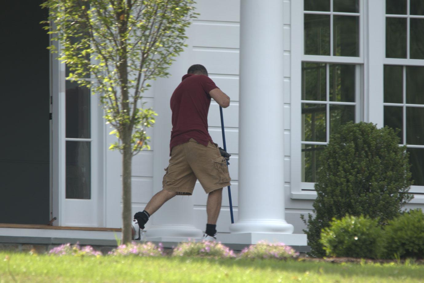 Fotis Dulos sweeps in front of his house.