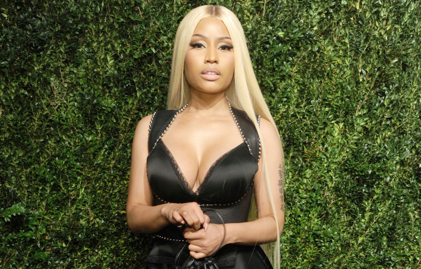 Nicki Minaj wears a cleavage baring black dress with silver stud accents and long blonde hair at the 2017 Vogue Fashion Fund Gala.