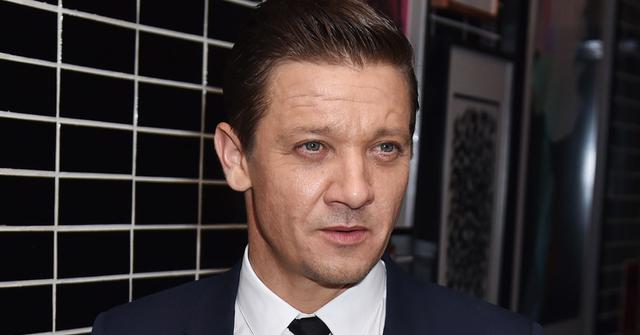 Jeremy Renner Wearing Black Tie and Dark Blue Suit With White Shirt