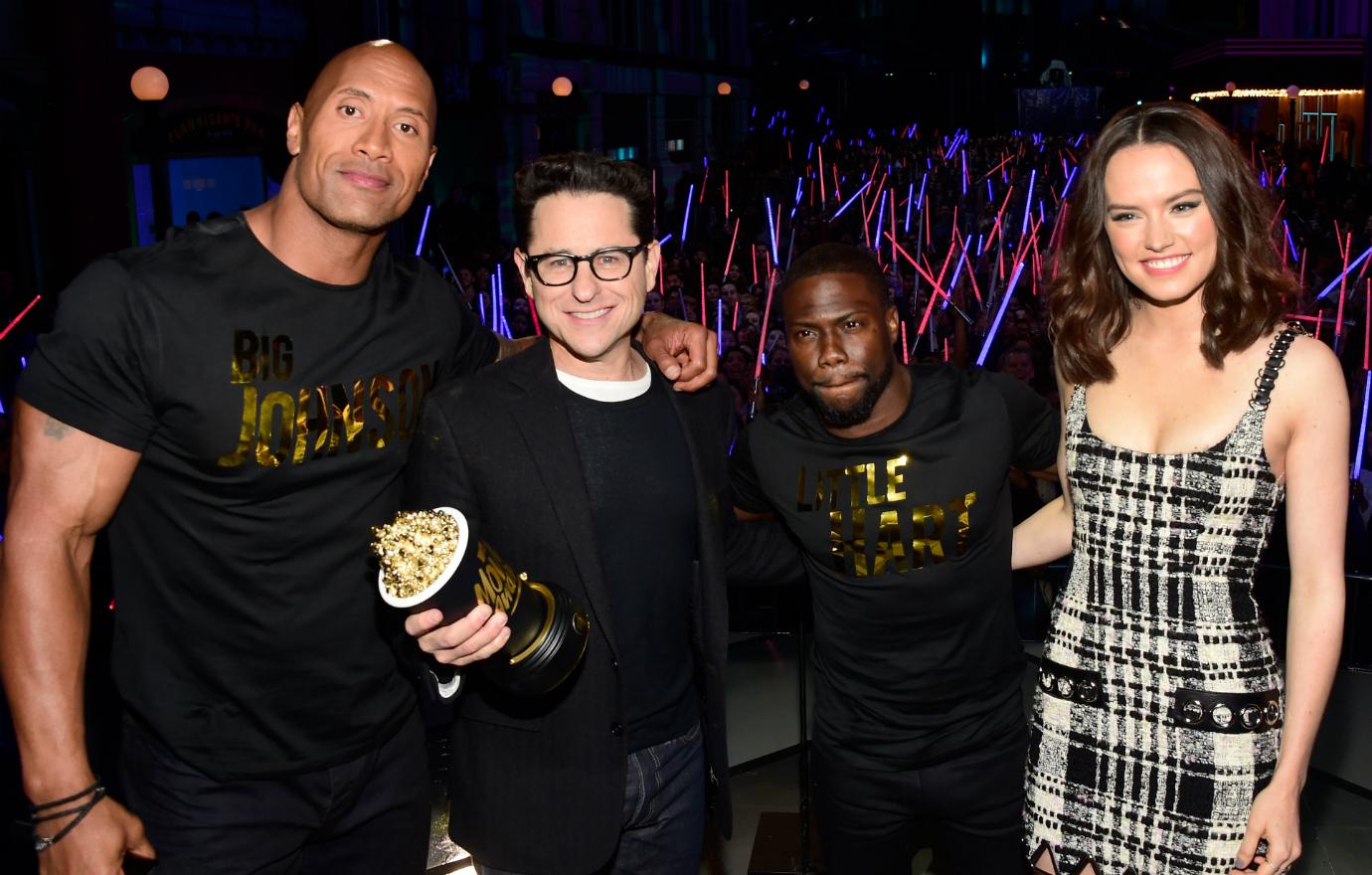 Writer/director J.J. Abrams (2nd L) and actress Daisy Ridley (R) accept the Movie of the Year award for 'Star Wars: The Force Awakens' with co-hosts Dwayne Johnson (L) and Kevin Hart (2nd R) onstage during the 2016 MTV Movie Awards at Warner Bros. Studios on April 9, 2016 in Burbank, California. MTV Movie Awards airs April 10, 2016