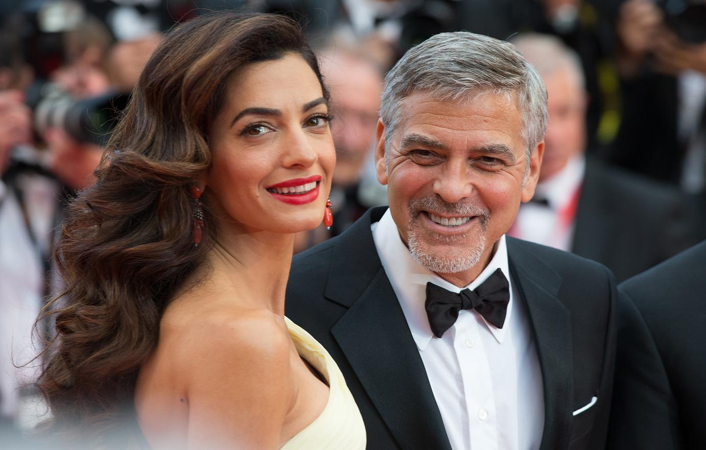 Amal Clooney in a white dress and George Clooney in a tux