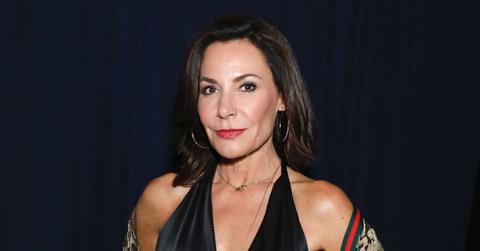 Luann de Lesseps Wearing Black Halter Jumopsuit With Gucci Scarf Around Her Arms