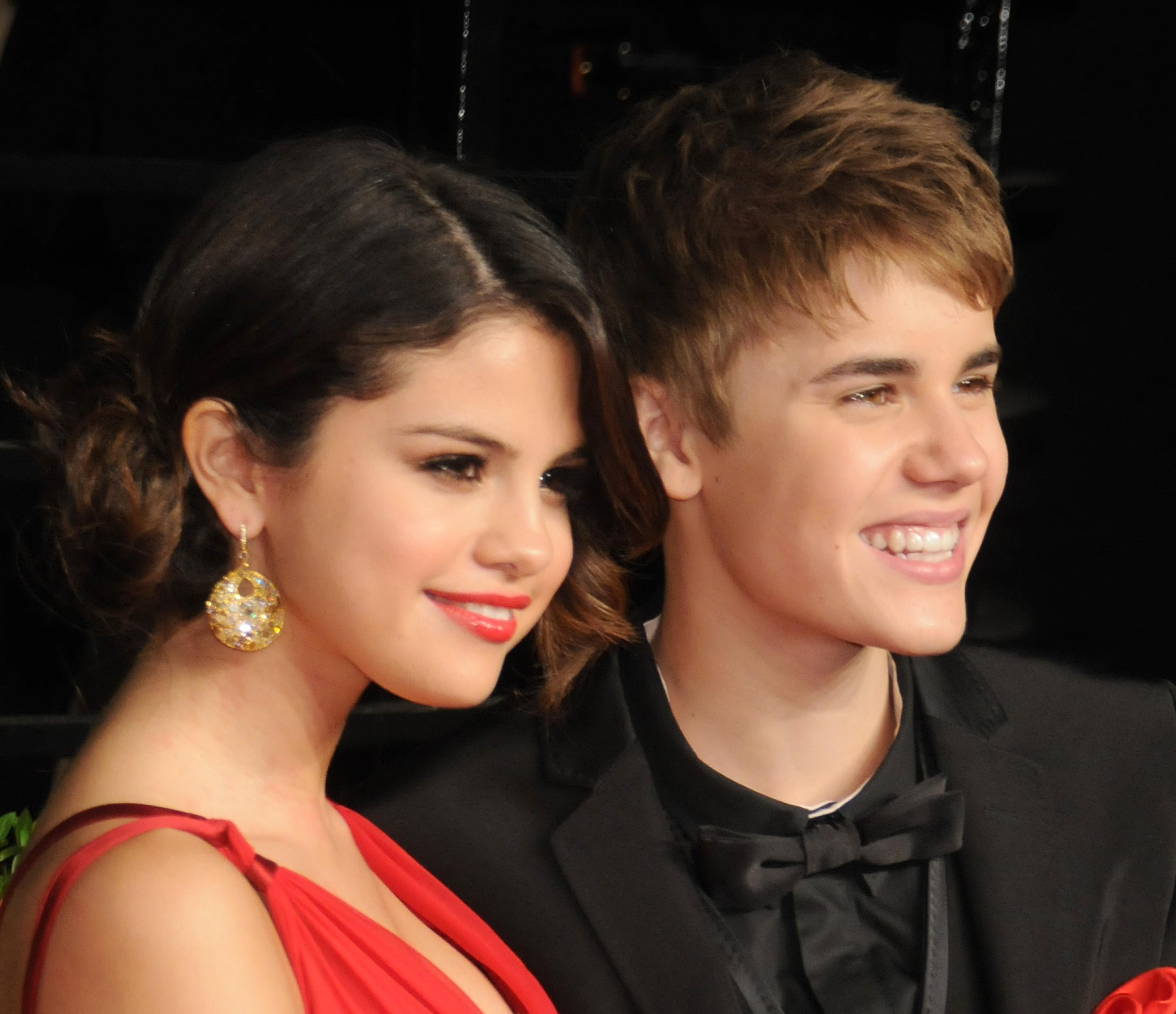 Selena Gomez wears a plunging red dress and Justin Bieber wears a black tux at the 2011 Vanity Fair Oscar party.