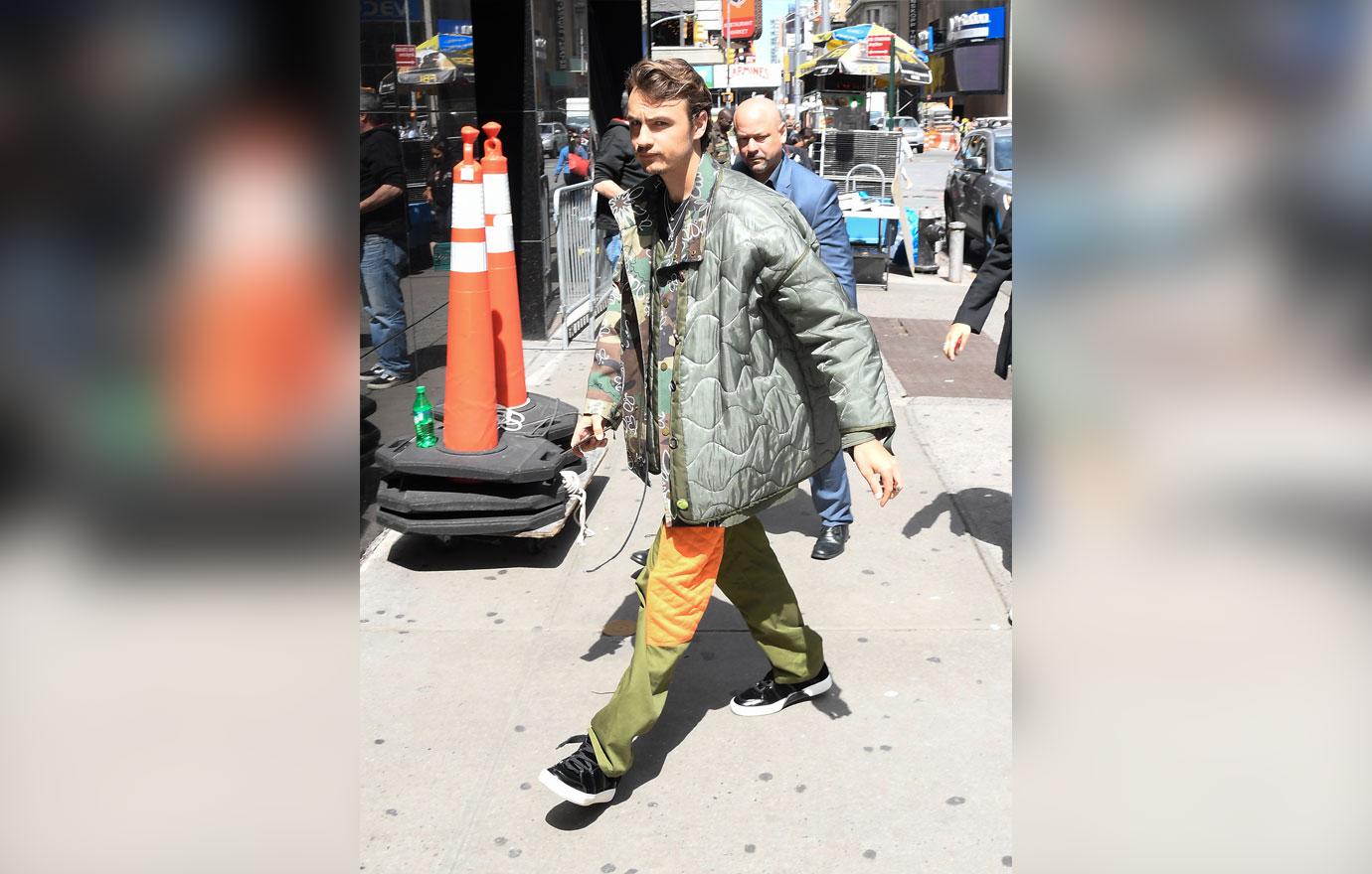 Brandon Thomas Lee wears a jacket and rainbow pants.