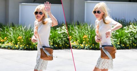 Anna Faris wears a white top and skirt while walking towards her car.