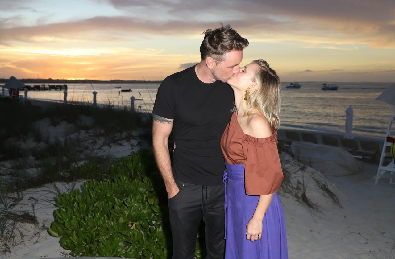 Dax Shepard and Kristen Bell share a kiss on a beach at sunset