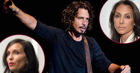 Chris Cornell wears a black shirt and has a guitar around his chest.